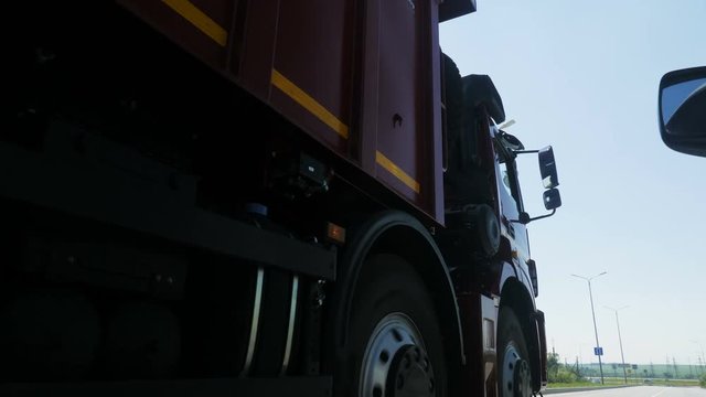 red tipper truck drives along highway against blue sky