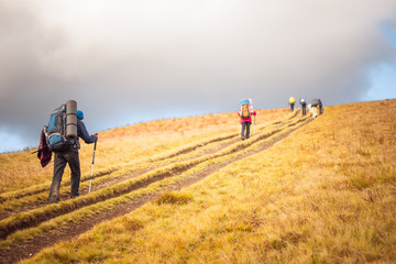 A group of people with backpacks hiking in the mountains.