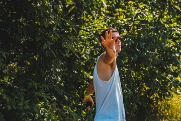 A guy in a sleeveless T-shirt is having fun in a nature park