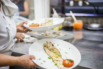 White fish fillet carried by cook in the restaurant