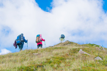 A group of people with backpacks hiking in the mountains.