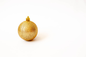 Golden Christmas toy in the form of a ball on a white background