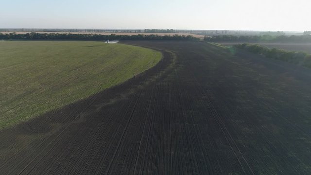 farming, biplanes flies over field with wheat and splashing chemicals against pests in bird eye view of vintage propelled plane flies beautifully over green plantation