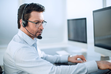 close up.businessman with a headset works in a modern office