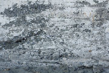 Old gray concrete wall with rough texture and white dye. Scratchy background with small blotches.