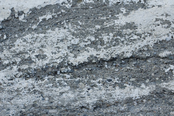 Old gray concrete wall with rough texture and white dye. Scratchy background with small blotches.