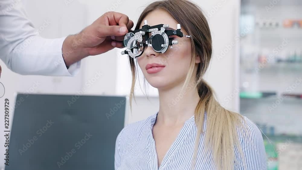 Wall mural eye exam. woman in glasses checking eyesight at clinic