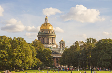 Park with a lawn, where a lot of people resting in front of St. Isaac's Cathedral.Saint-Petersburg.Sunny autumn day.