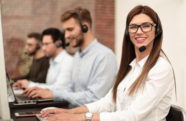 smiling call center employee sitting at his Desk