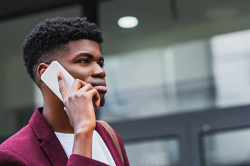 close-up shot of handsome young man talking by phone on street