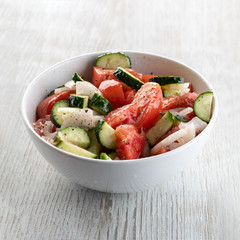 Sliced Cucumber, Tomato, Onion Salad With Olive Oil In A Plate On A White Wooden Background. Close Up.