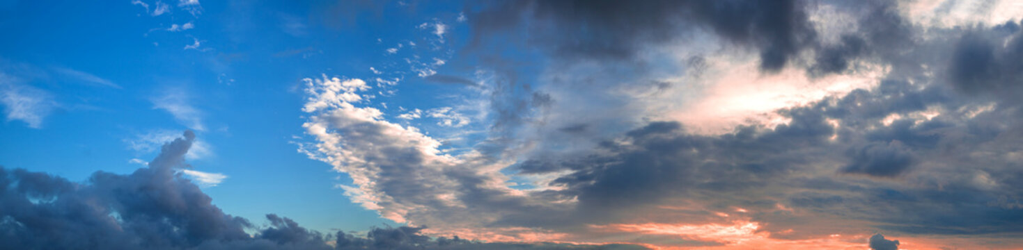 Beautiful panorama of the evening blue sky with colored clouds