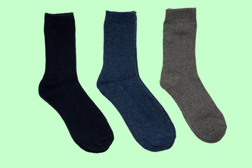Three warm socks on a green background