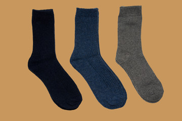 Three pairs of warm socks on brown background