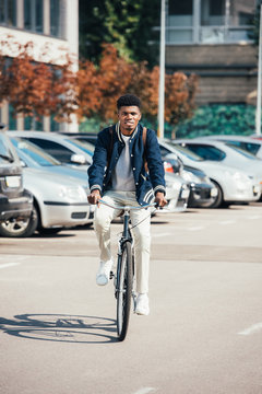 handsome african american man riding trendy bike in city