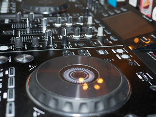 Sound mixing console detail, close up. DJ professional music console. Wide angle photo of black sound mixer controller with knobs and sliders. Professional audio mixing console with faders