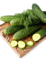 cucumbers and dill on wooden board