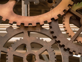 Low angle view to part of cogwheels. Vintage iron machine part in store. Abstract background of old industrial.