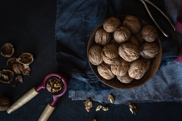 walnuts in a wooden cup, nutcracker and shells 