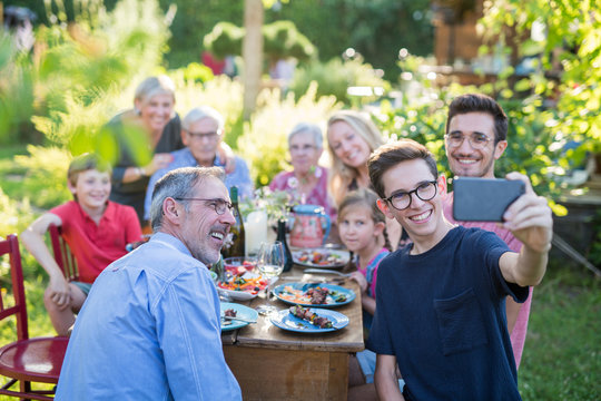 during a bbq a boy does a selfie with the whole family