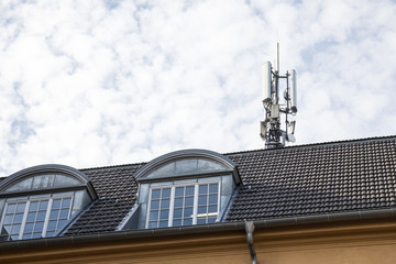 Mobilfunk Mast für Telekommunikation und Radio auf Ziegel Haus Dach in Deutschland