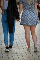 Girlfriends holding hands and walking on summer day. Loving each other. Samesex concept.