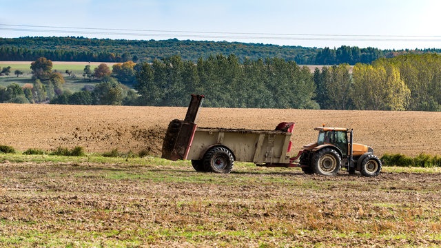 tracteur agricole qui fait un &eacute;pandage de fumier sur le champ
