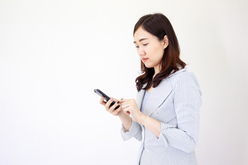 Fototapeta premium Portrait of beautiful Asian business girl using a smart phone close up on white background.