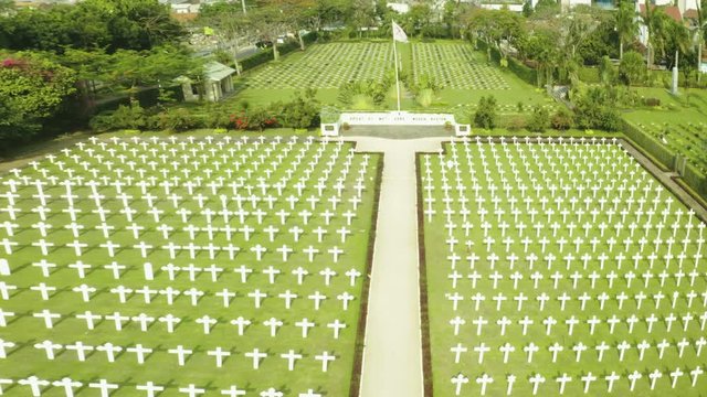 JAKARTA, Indonesia - October 09, 2018: Aerial view of pathway with rows of crosses in Ereveld Menteng Pulo or Dutch war cemetery in Jakarta, Indonesia. Shot in 4k resolution