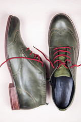 A pair of khaki color oxford man shoes with red shoelaced on white  background. Fashion footwear....