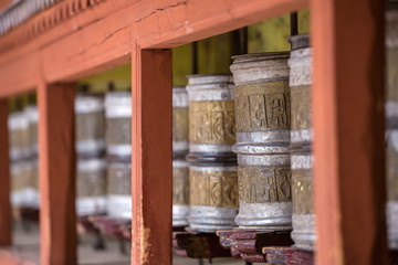 Tibetan buddhist praying wheels in Ladakh, India. Traditionally, the mantra Om Mani Padme Hum is written in Sanskrit on the outside of the wheel