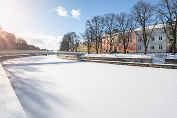 Colorful buildings by the shore of Aurajoki river at sunny winter day