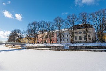 Fototapeta na wymiar Colorful buildings by the shore of Aurajoki river at sunny winter day
