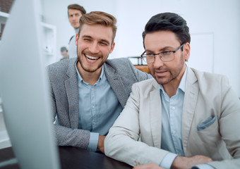 Fototapeta premium smiling colleagues looking at the computer monitor