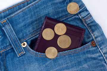 Wallet and fractional coin are lying in side pocket of blue jeans.