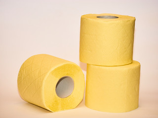 pyramid of yellow toilet paper isolated over white background