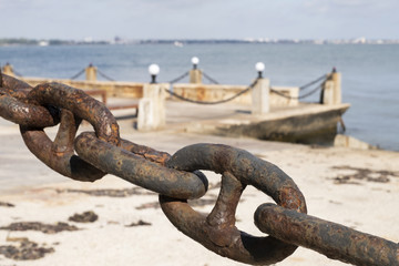 Rusty marine chain close-up against the background of the sea. Soft focus