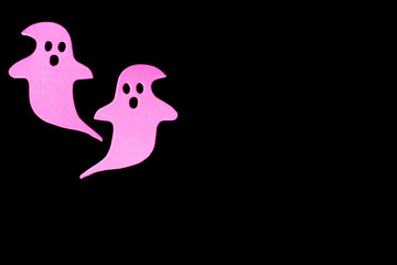 Halloween concept: two pink ghosts, free copy space, black background