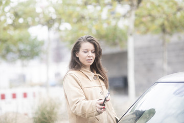 Junge Frau checkt Carsharing Auto