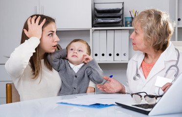 Obraz premium Adult female is puzzled of diagnosis of her son from woman doctor
