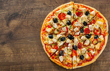 sliced Pizza with Chicken meat, Mozzarella cheese, tomato, olive. Italian pizza on wooden background
