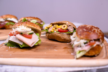 Mixed salad sandwiches with integral bread on wooden board