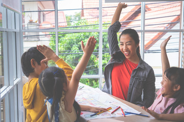 Teacher and Kindergarten students hand up for happiness