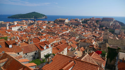 Fototapeta na wymiar View of the historic city of Dubrovnik. View from the city walls to the medieval old town, buildings dating from the Middle Ages located by the sea. A frequent place of turistic tours.