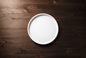 Blank white plate on wooden background. Flat lay.