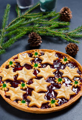 Christmas home sweet cake with jam on dark background. Green branches of a Christmas tree. Vertical photo