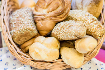 close up of freshly baked wheat bread with sesame and shugar in wicker basket