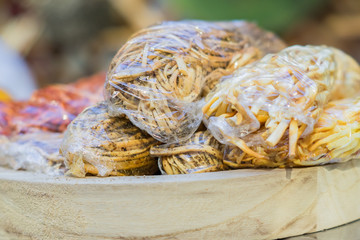 lose up of Armenian chechil - smoked cheese with spices on farmer's market.