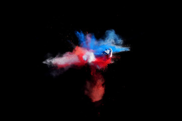 Abstract forms of powder paint and flour combined  together explode in front of a black background to give off abstract  multi colored cloud forms.