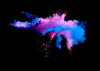 Abstract forms of powder paint and flour combined  together explode in front of a black background...
